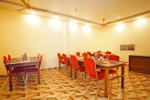 a conference room with wooden tables and red chairs at Holiday Beach Resort !! Beach Distance 50 Mts !! in Mandarmoni