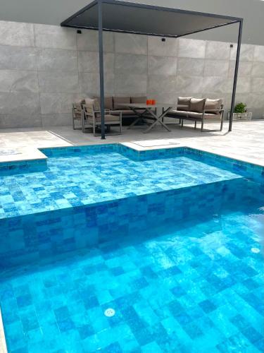 a large swimming pool with a table and chairs at Luxury house in Martil in Martil
