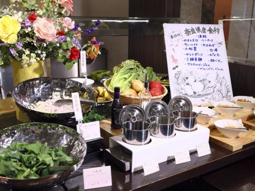 a table with bowls of food and vegetables on it at Hotel Nikko Nara in Nara