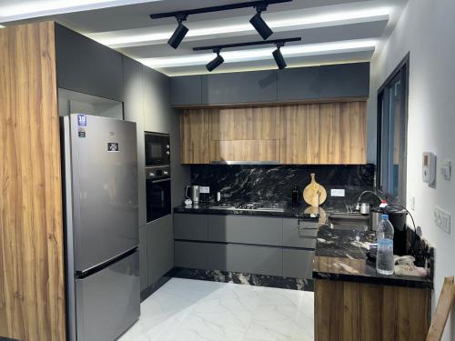 a kitchen with a refrigerator and a black counter top at Luxury house in Martil in Martil