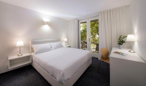 Habitación blanca con cama y ventana en Bed and Breakfast Saint Alliance, en Crikvenica