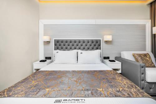 a bedroom with a large bed and a chair at Bareti Boutique Estate in Kallithea Halkidikis
