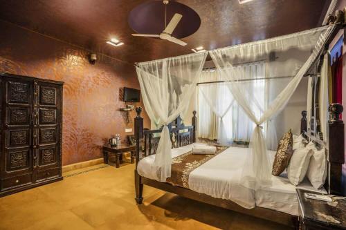 a bedroom with a canopy bed and a window at Jaisalmer Elite Castle in Jaisalmer