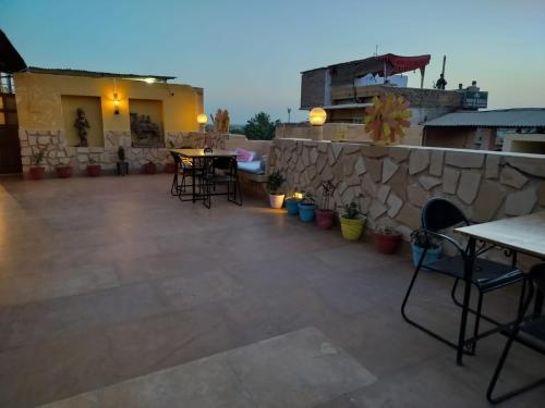 a patio with tables and chairs and a stone wall at Jaisalmer Elite Castle in Jaisalmer