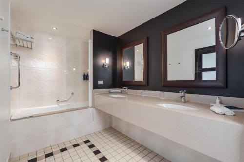 a bathroom with two sinks and a shower at Radisson Blu Hotel, Paris Boulogne in Boulogne-Billancourt