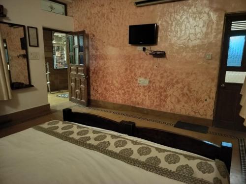 a bedroom with a bed and a tv on the wall at Jaisalmer Elite Castle in Jaisalmer