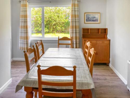 a dining room with a table and chairs and a window at Tigh Na Mhuillean in Gairloch