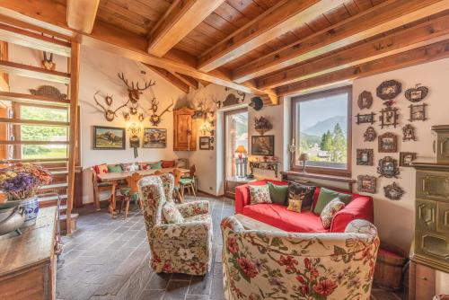 a living room with two couches and a table at Casa Scoiattolo, con balcone panoramico in San Vito di Cadore