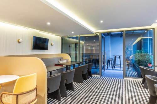 a waiting room with chairs and tables and a bar at Best Western Ratchada Hotel in Bangkok