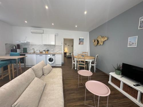 a living room and kitchen with a couch and a table at Cosy Pétunia - T2 - Centre ville in Pau
