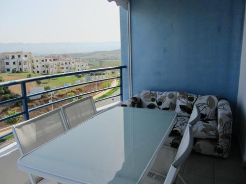 a white table and chairs in a room with a balcony at cabo dream 75 in Cabo Negro