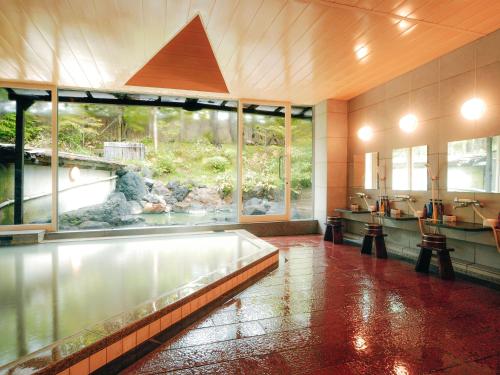 a bathroom with a large window and a large aquarium at Okunikko Konishi Hotel in Nikko