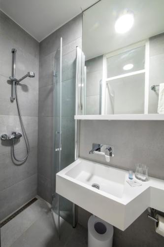 a bathroom with a white sink and a shower at Bed and Breakfast Saint Alliance in Crikvenica