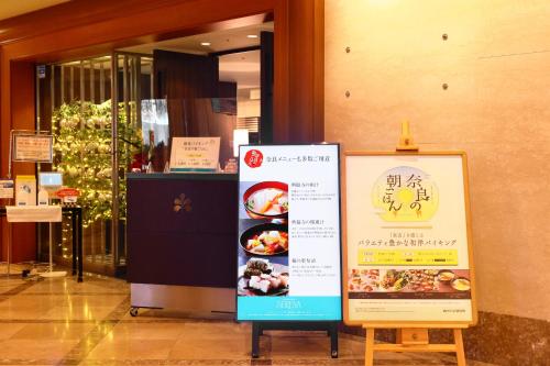 a sign in front of a building with a store at Hotel Nikko Nara in Nara