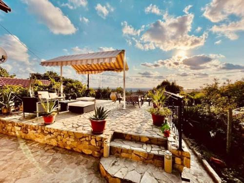 a patio with an umbrella and some plants at Guest House Yanakievi in Sinemorets