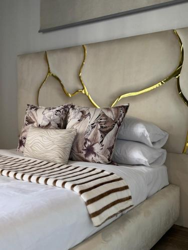 ヨハネスブルグにあるCelestial Lux Boho Homeのベッド(枕付きのヘッドボード付)