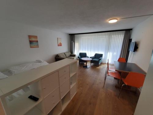 a bedroom with a bed and a desk and chairs at Cresta Apartments - Studios in Davos
