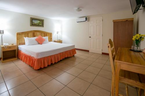 a bedroom with a bed with an orange skirt on it at Hotel La Estacion in Granada