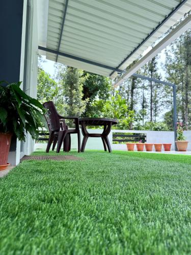 a patio with a picnic table and green grass at Anya Retreats Nature Homestay in Kushālnagar