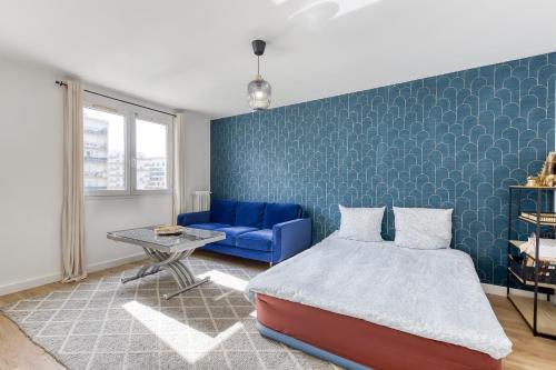- une chambre avec un lit et un mur bleu dans l'établissement Choisy Modern RER C Tram Paris, à Choisy-le-Roi