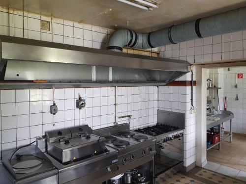a kitchen with a stove and a sink in it at Top Unterkunft für Monteure in Auf der Wiese