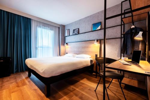 a hotel room with a bed and a desk and a laptop at ibis Rouen Centre Champ de Mars in Rouen