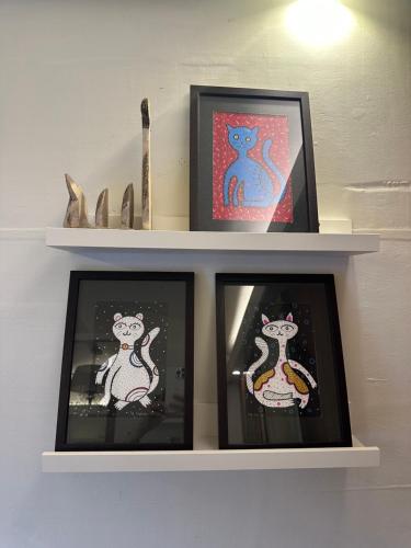 a shelf with three pictures of rats on it at Sinurambi Cottage Rental in Penampang