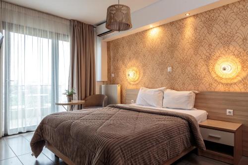 Una habitación de hotel con una cama y una ventana grande. en Limani Comfort Rooms, en Tesalónica