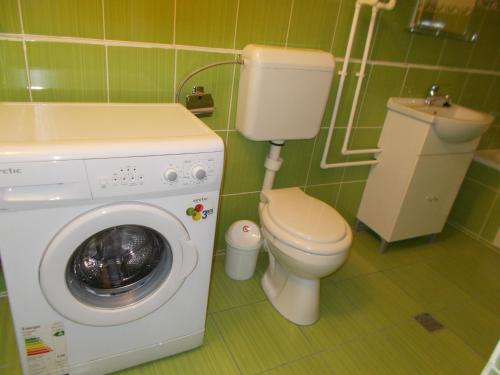 a bathroom with a toilet and a washing machine at Casa Vlad in Constanţa