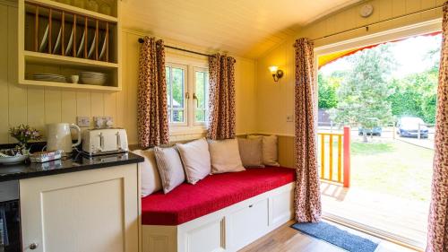 a red bench in a kitchen with a window at La Rouge Roulotte in Hassocks