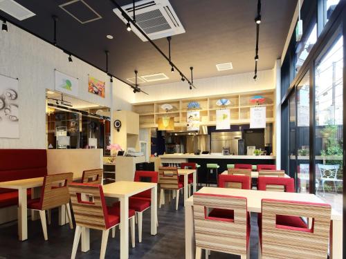 a restaurant with wooden tables and red chairs at APA Hotel Asakusa Kaminarimon Minami in Tokyo