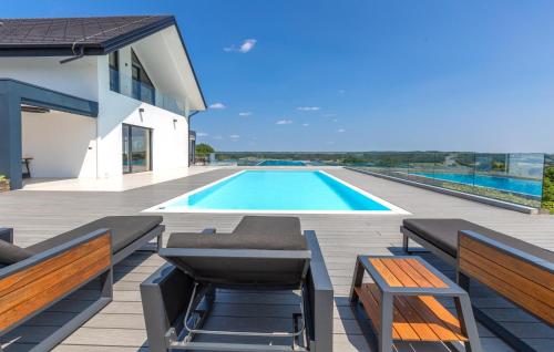 a swimming pool on a deck with benches and a house at Stunning Apartment In Rogasovci in Rogašovci