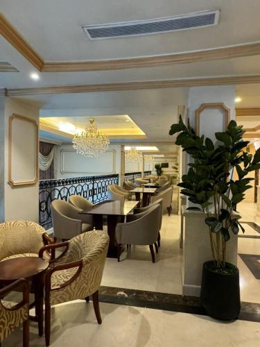 a dining room with a table and chairs and a chandelier at فندق بارك رويال in Al Masfalah