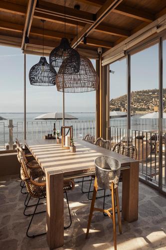 a wooden table and chairs in a room with a view of the ocean at Sun Hotel By En Vie Beach in Alanya