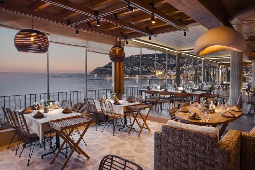 a restaurant with tables and chairs and a view of the ocean at Sun Hotel By En Vie Beach in Alanya
