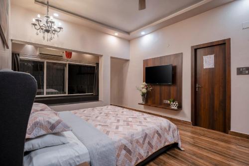 a bedroom with a bed and a flat screen tv at BOHO Bari in Kolkata