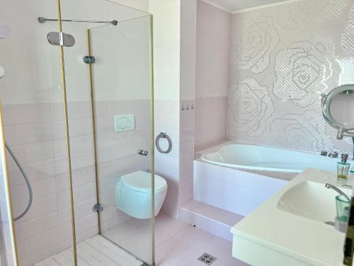 a bathroom with a shower and a toilet and a sink at Coralia Luna Park Apartments in Mamaia
