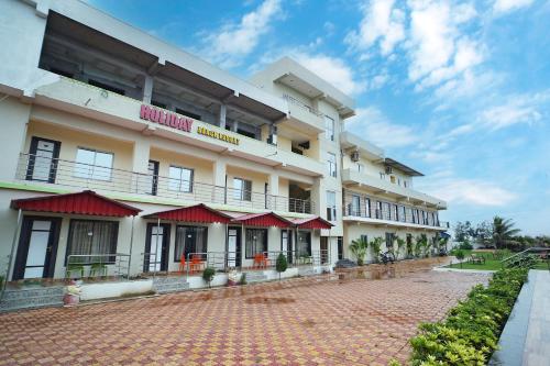 a hotel with red awnings on the side of it at Holiday Beach Resort !! Beach Distance 50 Mts !! in Mandarmoni