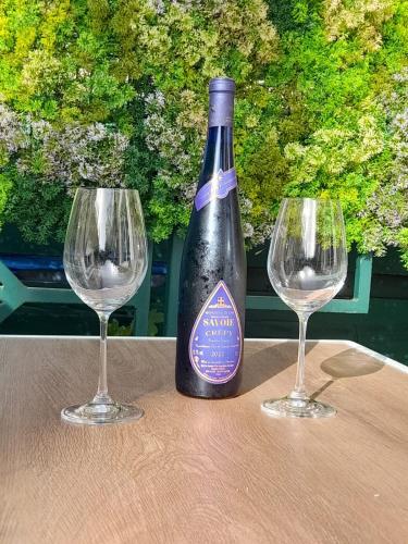 - une bouteille de vin assise entre deux verres à vin dans l'établissement Le Napolitain, à Thonon-les-Bains
