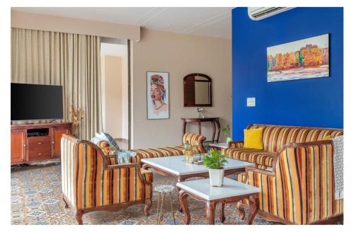 a living room with couches and a table and a tv at Dia Hotels and Homes Nerul Goa - Villas and Apartments in Nerul
