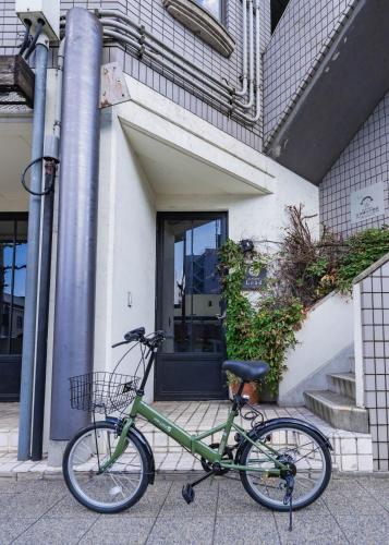 a green bike parked in front of a building at お宿Ｇａｎ福田町 in Takamatsu