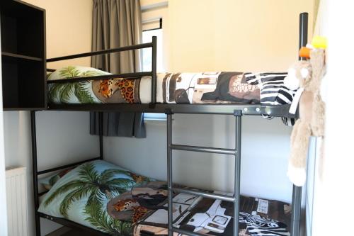 a bedroom with two bunk beds in a room at Fijn chalet vlakbij Zeeuwse kust, op familiepark VP047 in Heinkensand