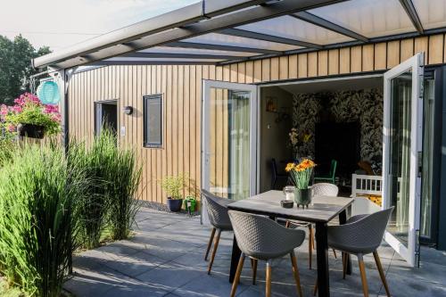a patio with a table and chairs on it at Fijn chalet vlakbij Zeeuwse kust, op familiepark VP047 in Heinkensand