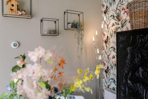 a room with flowers and mirrors on the wall at Fijn chalet vlakbij Zeeuwse kust, op familiepark VP047 in Heinkensand