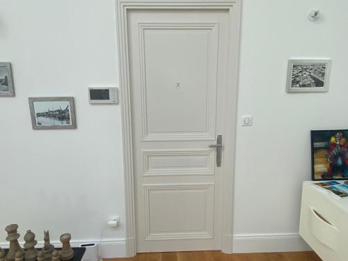 a white door in a white room with a chessboard at La Hugotine in Marseillan