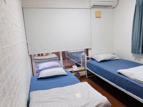 a bedroom with two beds and a window at スペース海浜幕張ハウス in Chiba