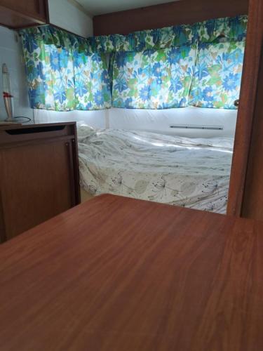 une petite chambre avec un lit dans une pièce dans l'établissement Caravane 70's, à Saint-Marcet