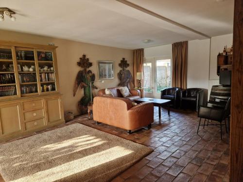 a living room with a couch and a table at Rozenhofje Asselt - Roermond in Swalmen