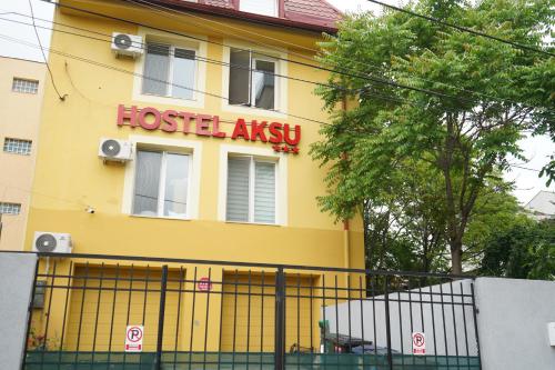 a yellow building with a hostel assay sign on it at Hotel AKSU in Bucharest