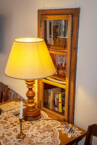 a lamp sitting on top of a table with a candle at Casa Savri in Sighişoara